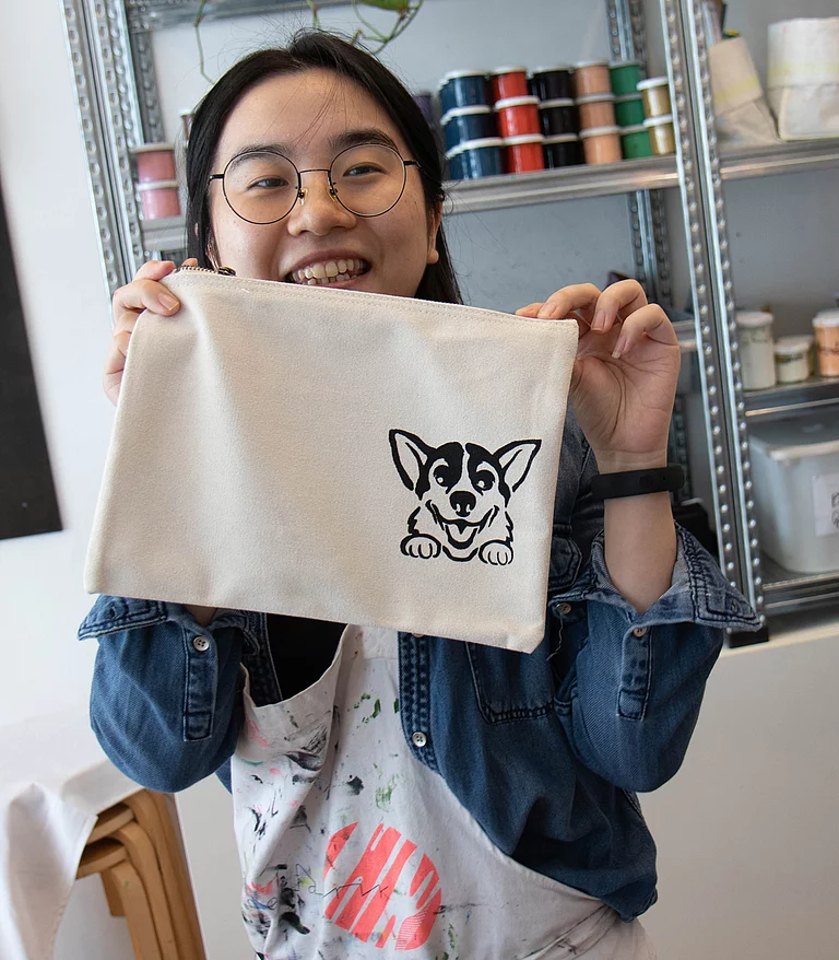 DIY Team Event Foto: Ein Teammitglied hält eine selbstgestaltete Tasche ins Bild