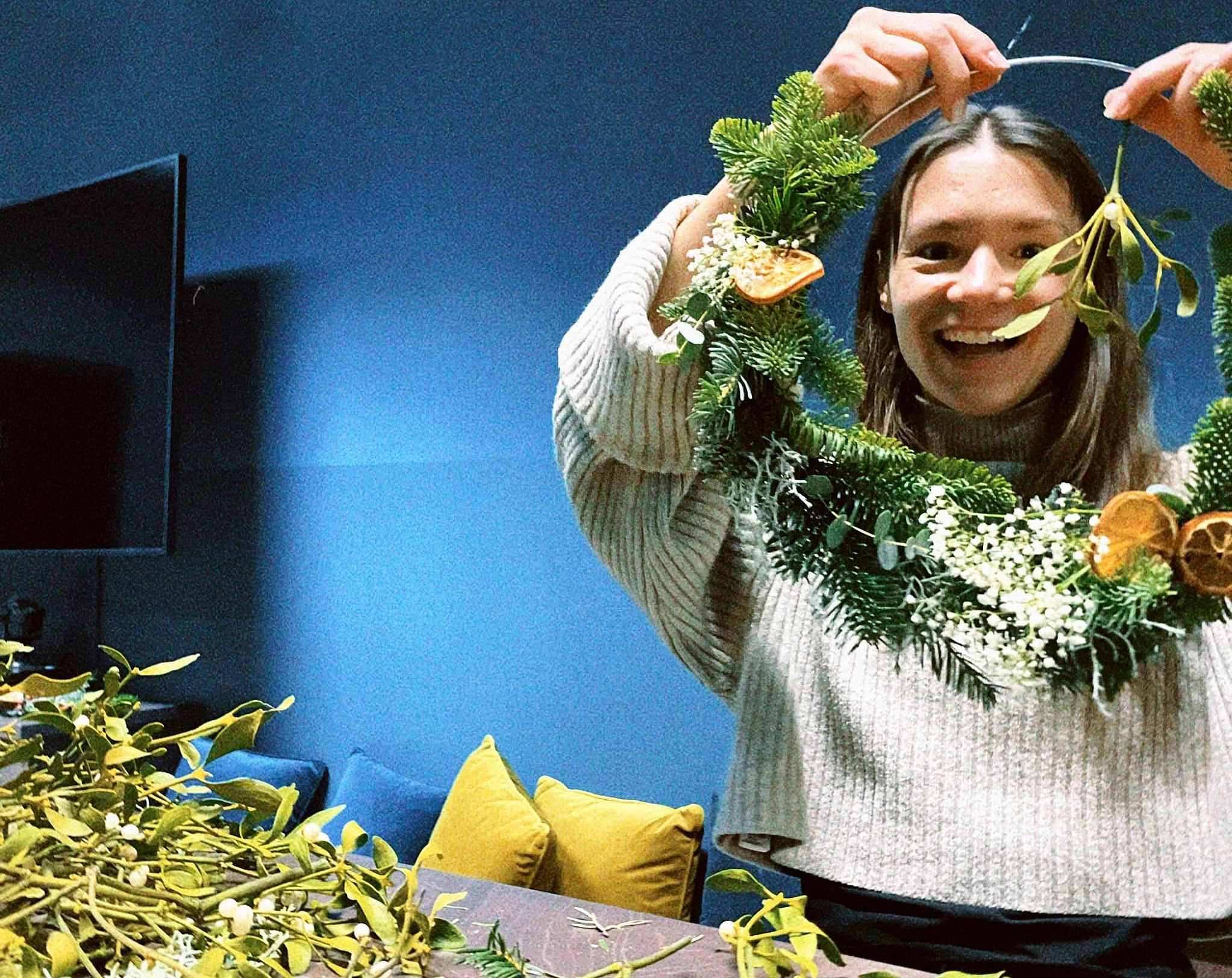 Foto: Eine Mitarbeiterin bastelt einen Weihnachtskranz