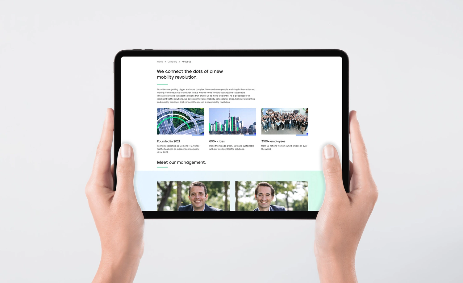 Hands holding an Ipad showing the Yunex website