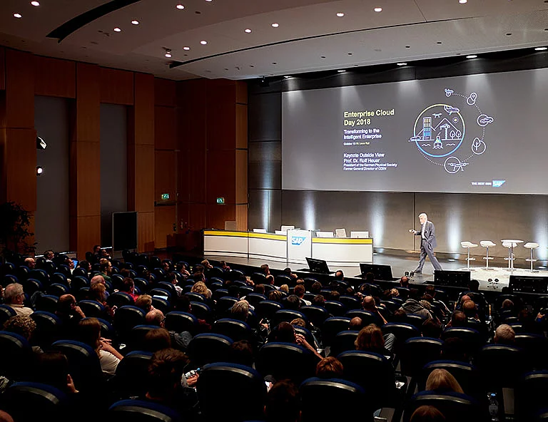 Presentations Pictured is a room full of people listening to a presentation for SAP, created by design agency SNK